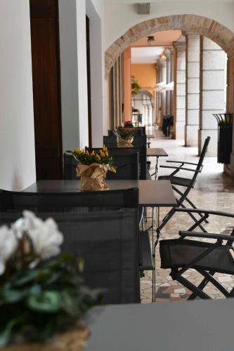 a row of tables and chairs with flowers on them at Panorama Hotel Friuli - Boutique Hotel in San Daniele del Friuli
