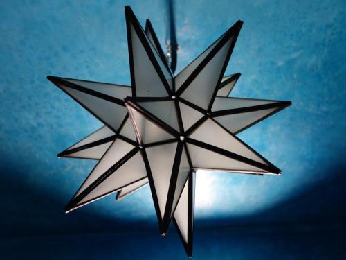 a hanging star chandelier with a blue background at Riad Sabah in Fès
