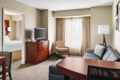 a hotel room with a couch and a tv at Residence Inn by Marriott Charleston North/Ashley Phosphate in Charleston