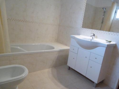 a bathroom with a sink and a tub and a toilet at Casa Katarina in Luz