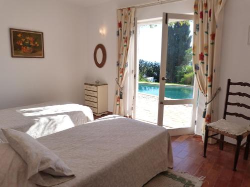 a bedroom with two beds and a door to a pool at Casa Katarina in Luz