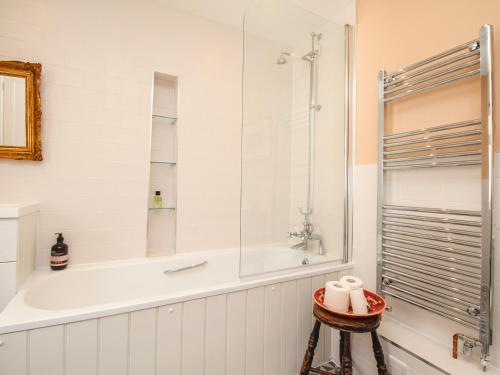 une salle de bain blanche avec une baignoire et une douche dans l'établissement The Corner House, à Weymouth