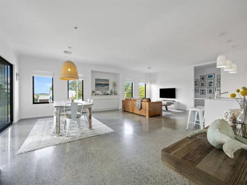 a white living room with a table and a couch at Whale Tails Augusta - stylishly modern in the town of Augusta in Augusta