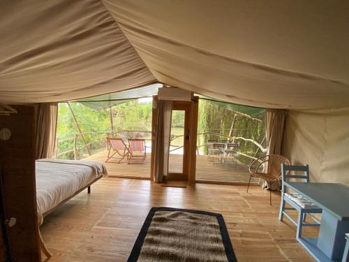 a bedroom with a tent with a deck with a table at Parque dos Monges in Alcobaça