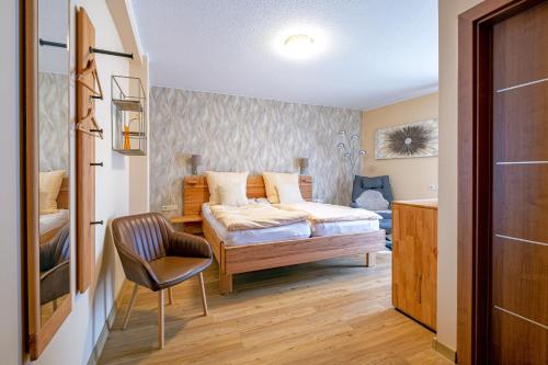 ein Schlafzimmer mit einem Bett und einem Stuhl darin in der Unterkunft Alt Wehlheiden in Kassel
