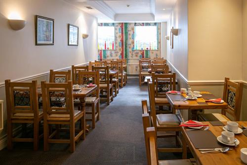 a dining room with wooden tables and chairs at Tralee Townhouse in Tralee