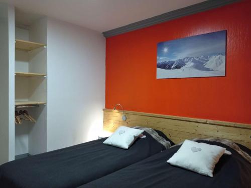 two beds in a room with an orange wall at "Superbe Appartement 8/10 pers, 105m², Centre Station, Accès Direct Pistes" - FR-1-545-22 in Val Thorens