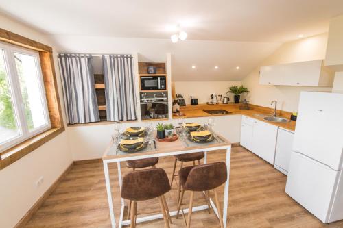 une cuisine avec une table et des chaises dans une pièce dans l'établissement Le Milan Royal - Montmin, à Montmin