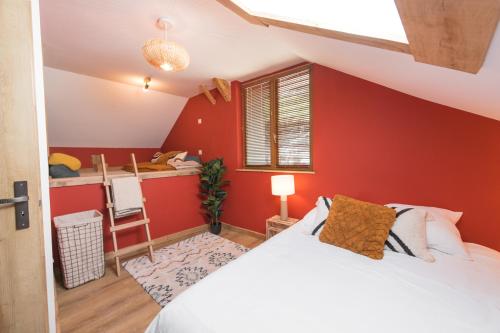 a bedroom with red walls and a bed and a desk at Le Milan Royal - Montmin in Montmin