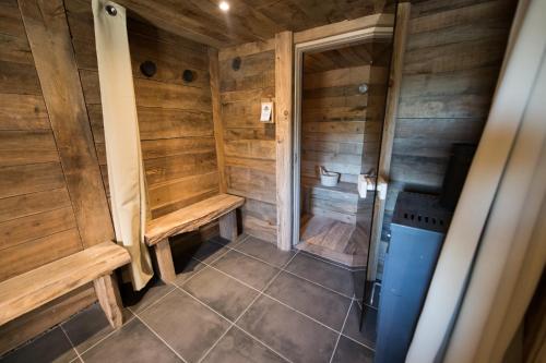 ein Badezimmer mit Holzwänden und -bänken und einem WC in der Unterkunft Le Milan Royal - Montmin in Montmin