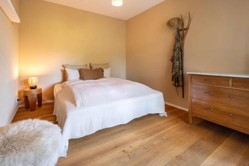 a bedroom with a white bed and a wooden floor at 10min zu den Bergbahnen Tiefgarage & Wifi inkl. Bergsicht & Ruhe in Trinsermühle
