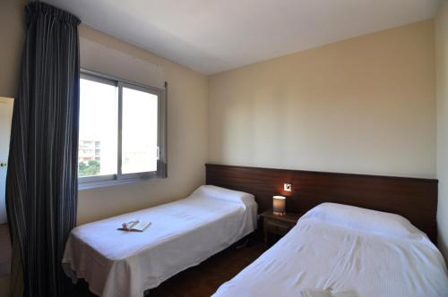 ロザスにあるRnet - Casablancaのベッド2台と窓が備わるホテルルームです。
