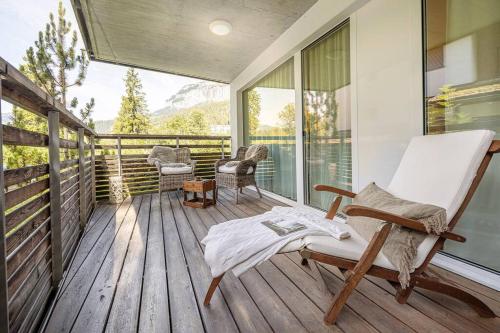 a porch with a rocking chair on a wooden deck at 10min zu den Bergbahnen Tiefgarage & Wifi inkl. Bergsicht & Ruhe in Trinsermühle