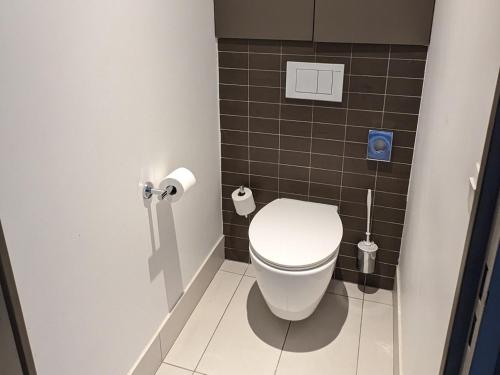 a bathroom with a white toilet in a stall at Disneyland Deluxe flat, outside pool, Climatisation, 1 min to Disney Parks in Serris