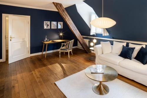 a living room with a white couch and a table at Schloss Hertefeld & Hertefeldhof in Weeze