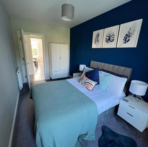 a bedroom with a large bed with blue walls at Stunning 2 Bedroom River View Apartment in Perth