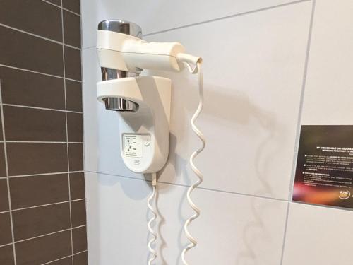 a phone hanging on a wall in a bathroom at Disneyland Deluxe flat, outside pool, Climatisation, 1 min to Disney Parks in Serris