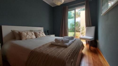 ein Schlafzimmer mit einem großen Bett und einem Fenster in der Unterkunft Flaghouse in Calheta