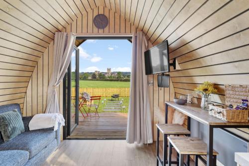 a room with a couch and a tv in a tiny house at The West Front, Cathedral View in Wells