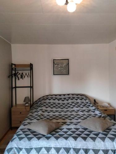 une chambre avec un lit avec une couverture à carreaux dans l'établissement Chambres d'Hôtes Arnold, à Dambach-la-Ville