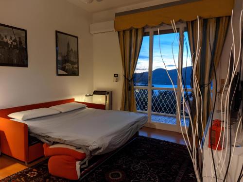 - une chambre avec un lit et une grande fenêtre dans l'établissement Garda Panoramic House, à Torri del Benaco