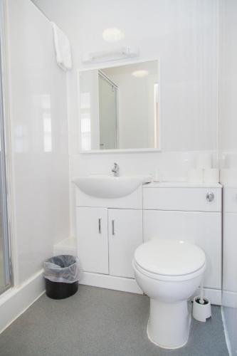 a white bathroom with a toilet and a sink at The Beechfield Hotel in Blackpool