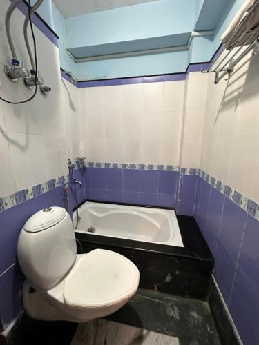 a bathroom with a toilet and a bath tub at Hotel Gajraj in Gangtok