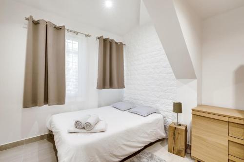 a white bedroom with a bed with towels on it at 302 Suite Dylan - Superb apartment in Paris in Paris