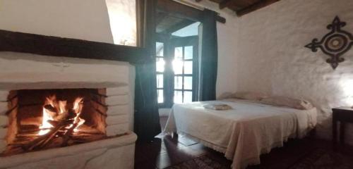 a bedroom with a fireplace with a bed in it at Darenas Hacienda in Aucallama