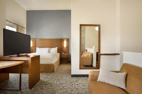 a hotel room with a bed and a mirror at Residence Inn by Marriott Phoenix Chandler/South in Chandler