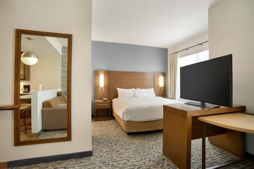 a hotel room with a bed and a mirror at Residence Inn by Marriott Phoenix Chandler/South in Chandler