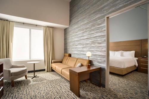a hotel room with a bed and a couch at Residence Inn by Marriott Phoenix Chandler/South in Chandler