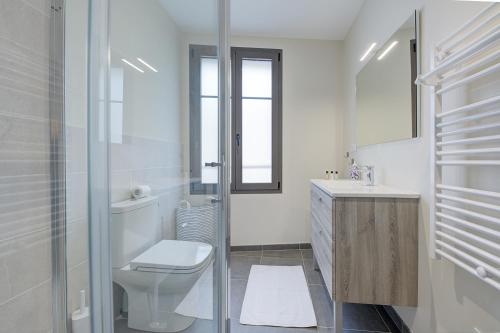a white bathroom with a toilet and a sink at Nids de Loire in Tours