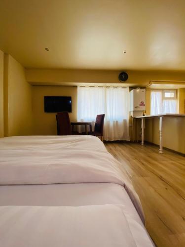 um quarto com uma cama, uma mesa e uma televisão em Apartament Luna em Piatra Neamţ