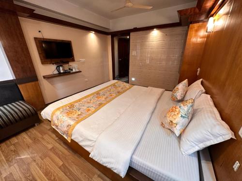 a bedroom with a large bed and a television at Hotel Gajraj in Gangtok