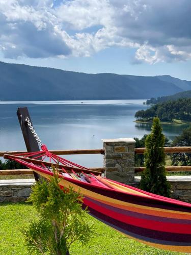 a hammock on a fence with a view of a lake at Villa ART in Dospat