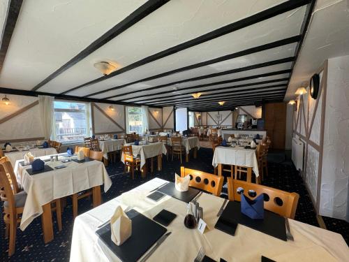 a dining room with white tables and chairs and tablesearcher at The Carpenters Arms Rooms in Broadway, Laugharne in Laugharne
