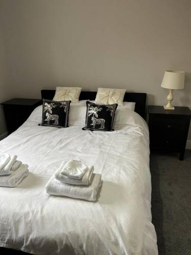 a white bed with two towels on top of it at Meadow View in Alfreton