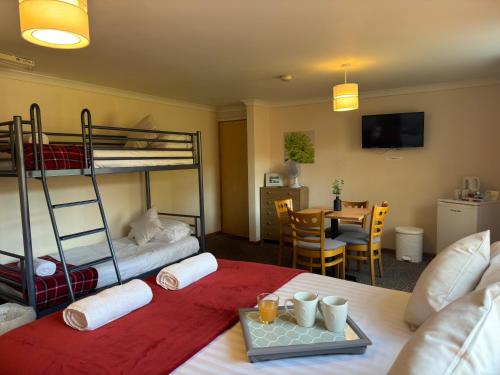 a bedroom with bunk beds and a dining room with a table at The Carpenters Arms Rooms in Broadway, Laugharne in Laugharne