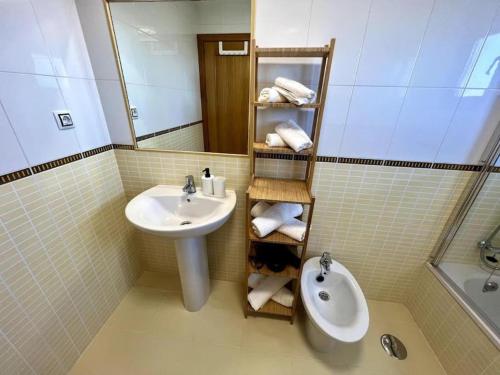 een badkamer met een wastafel, een toilet en een spiegel bij Dreamsville Fuerteventura a 5 minutos de Lajares in Lajares