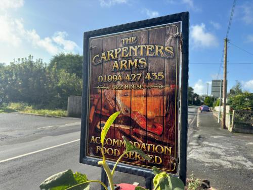 a sign for the carpenters arms on the side of a road at The Carpenters Arms Rooms in Broadway, Laugharne in Laugharne