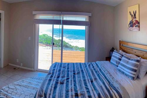 1 dormitorio con 1 cama y vistas al océano en Redwood Coast Beach Front Home California, en Smith River