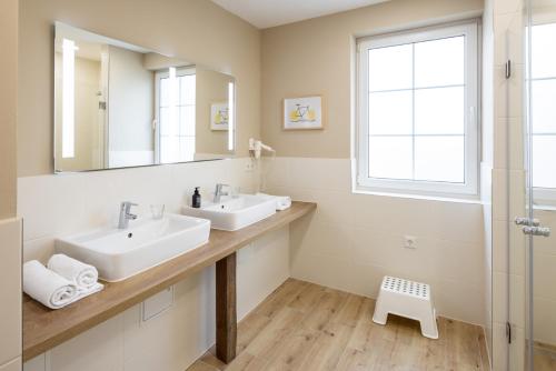 a bathroom with two sinks and a mirror at Schloss Hertefeld & Hertefeldhof in Weeze