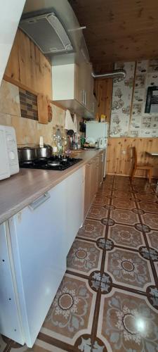 a kitchen with a counter and a tile floor at KOMFORT in Berehove