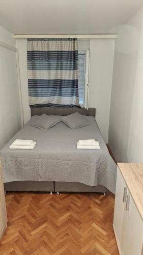 a bed in a small room with a window at Apartment Luce in Split