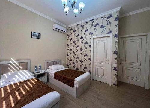 a hotel room with two beds and a chandelier at HOTEL MRT in Mingachevir