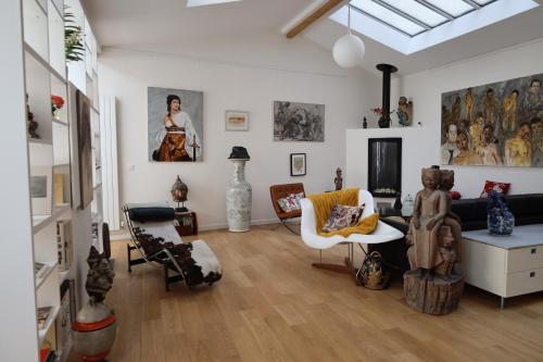 巴黎的住宿－Loft, atelier artiste Montmartre，客厅里摆放着许多家具和绘画作品
