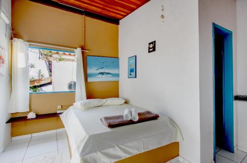 1 dormitorio con 1 cama con sábanas blancas y ventana en Pousada Canto do Mar Ilha Grande, en Praia de Araçatiba