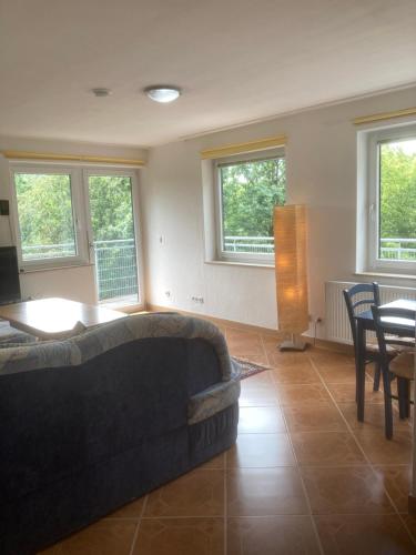 a living room with a couch and a table and windows at Immensee in Ronshausen