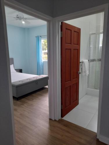 Serenity Seaview Suite في Anse La Raye: غرفة نوم بسرير وباب مفتوح